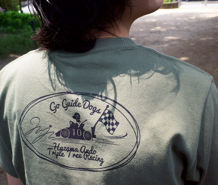 Juju選手がオリーブのTシャツを着てバックプリントデザイン部分アップ写真