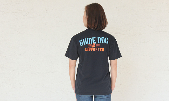 女性モデルがネイビーカラーのTシャツを着てバックプリントを見せている写真