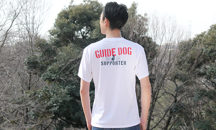 男性モデルがホワイトカラーのTシャツを着てバックプリントを見せている写真