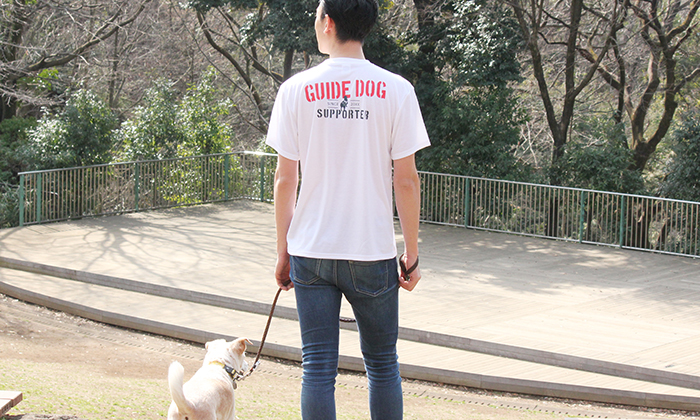 男性モデルが犬と散歩する写真