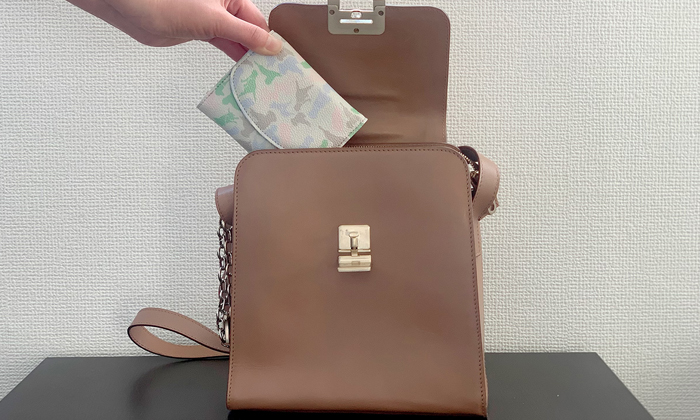 財布をバッグに入れている。