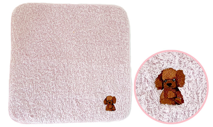 トイプードルの刺しゅうがワンポイントで入っているハンカチタオル。タオルの色はピンク。