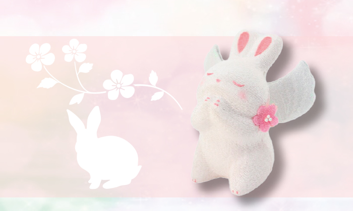 うさぎのお祈り天使。白いうさぎに白い翼と首元にピンクのコサージュがついています。