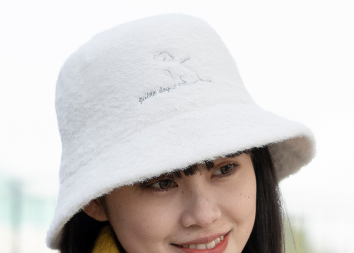 女性がアイボリーの帽子を被っている写真