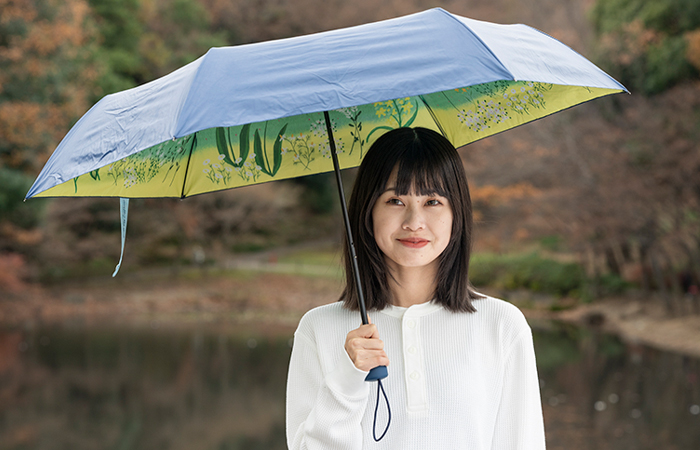 女性が天面も見えている傘を持っている写真