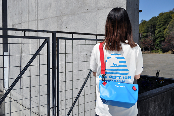 女性がブルーのお散歩バッグをメッセンジャーバッグのように後ろに背負っている写真