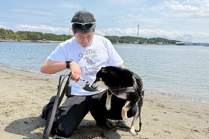 柴犬に水を飲ませている男性と柴犬のシルエットデザインの着用写真