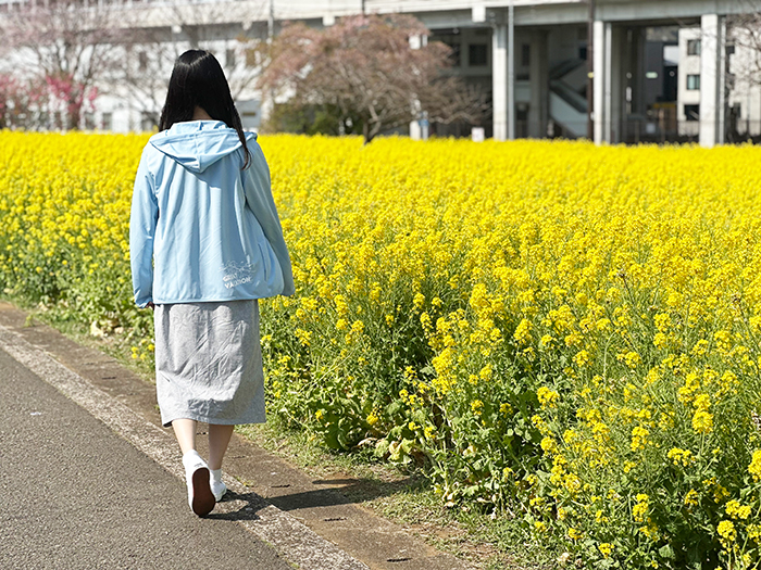 バック側女性がグレーのワンピースにライトブルーを合わせた着用写真