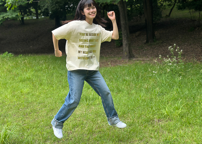 アイボリーのTシャツを着て飛び跳ねている女性