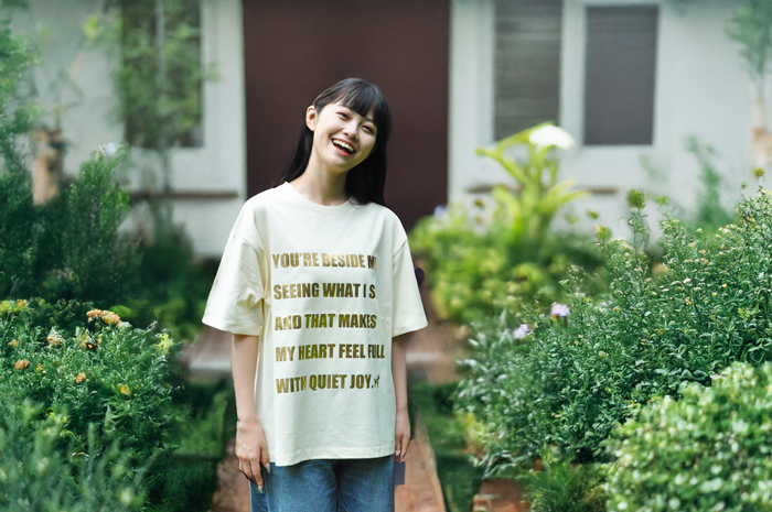 アイボリーのTシャツを着て微笑む女性