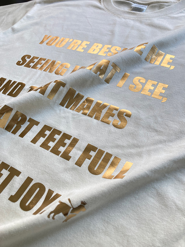 アイボリーのTシャツにはマットゴールドの箔プリント