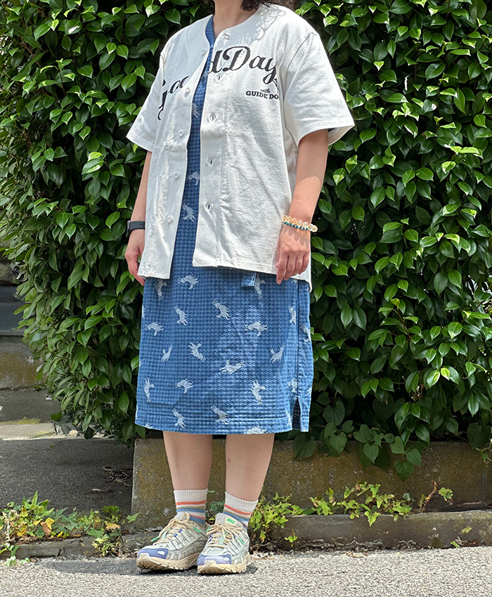 ブルーのワンピースに黒のロゴのベースボールTシャツを羽織っている写真