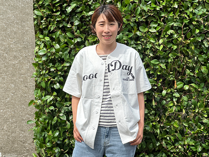 女性がデニムパンツをはきボーダーシャツの上から羽織っている写真