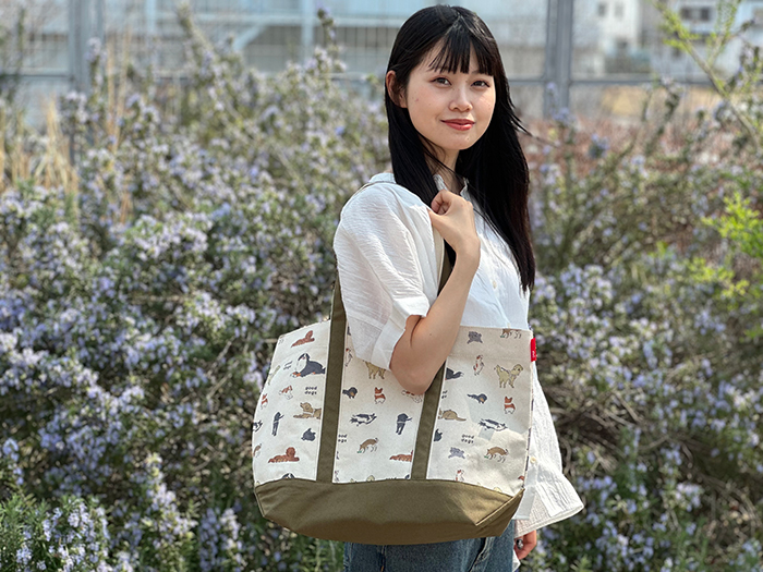 女性が肩からミディアムサイズのトートをかけている写真