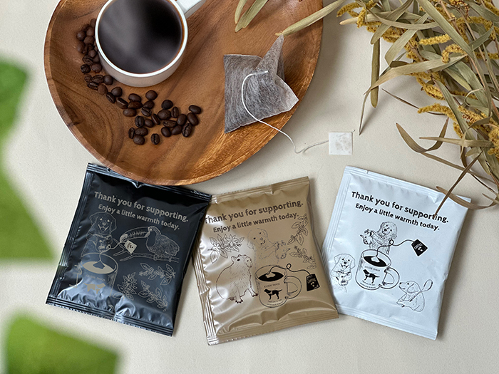 ティーバッグタイプのドリップコーヒー3種とコーヒーが入ったカップが置かれている。