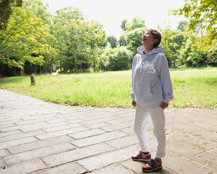 女性がホワイトジーンズの上にアッシュのパーカーを着ている写真