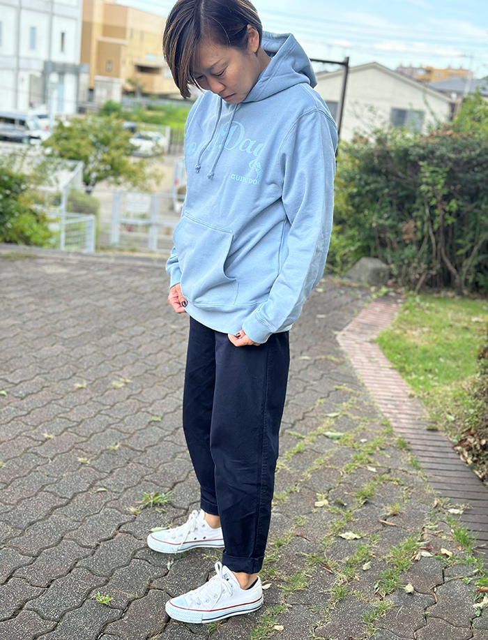女性がネイビーのスウェットの上にアシットブルーのパーカーを着ている写真