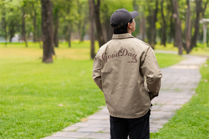 男性がベージュのジャケットを着用し、後ろを向いている写真