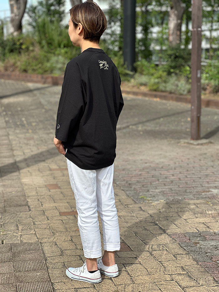 女性がバックプリントのブラックを着て背を向けている写真