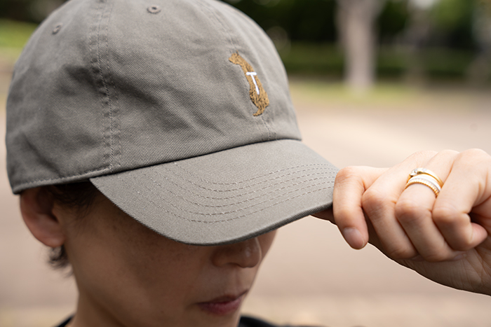 女性がオリーブのキャップをかぶっている写真。