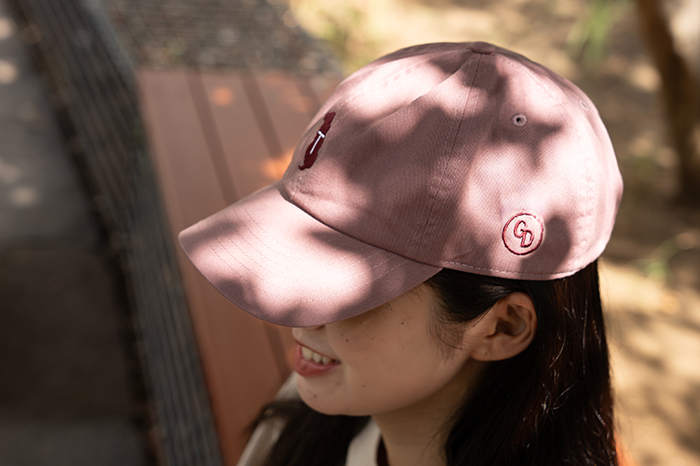 女性がモーブのキャップを被っている写真。