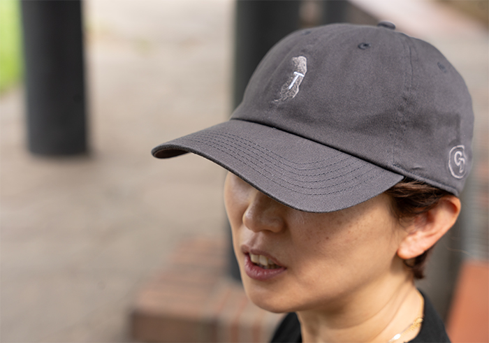 女性がチャコールのキャップをかぶっている写真。