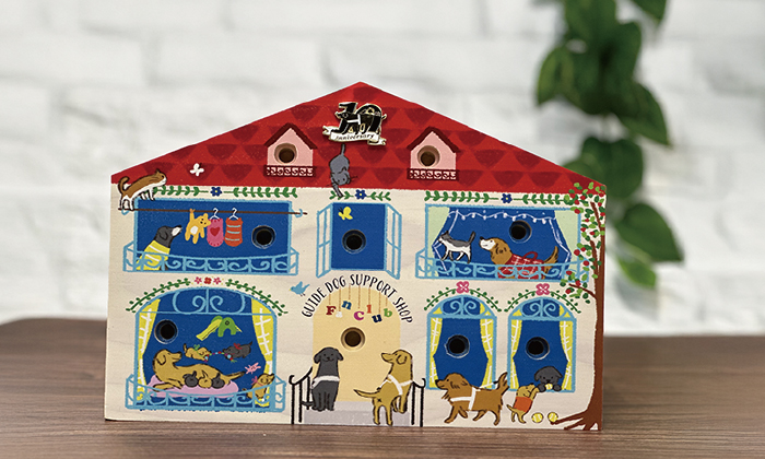 10個のピンバッジホルダーが付いた家形の置台の写真