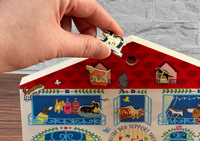 ピンバッジディスプレーにピンバッジを取り付けようとしている写真