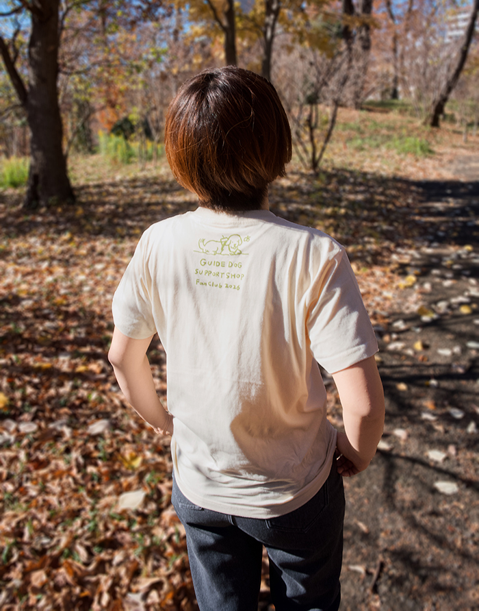 女性がアイボリーのTシャツを着用し後ろを向いている写真