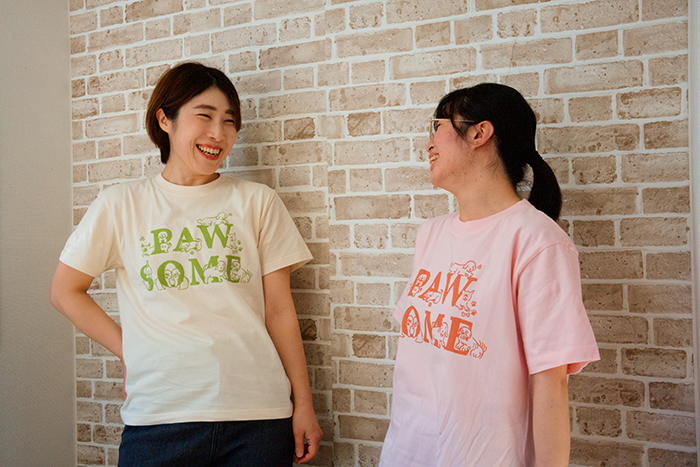 女性がアイボリーのTシャツとピンクのTシャツを着用している写真