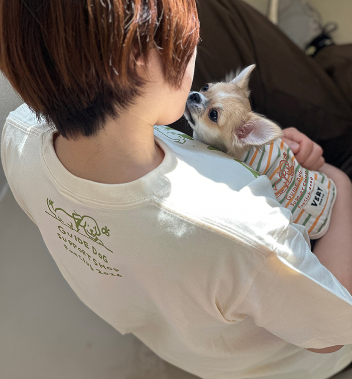 女性がアイボリーのファンクラブTを着用し、抱っこしたチワワがファンクラブワンTを着ている写真