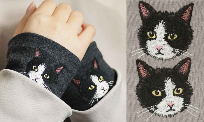 左側は女性が杢ブラック生地に猫のハチワレの刺繍がされているハンドマフラーを着けている写真。右側はサンドベージュにハチワレの正面と斜め横を向いている刺?墸の写真