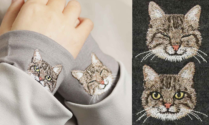 左側は女性がサンドベージュ生地にキジトラの刺繍がされているハンドマフラーを着けている写真。右側は杢ブラックにキジトラの正面と斜め横を向いている刺?墸の写真