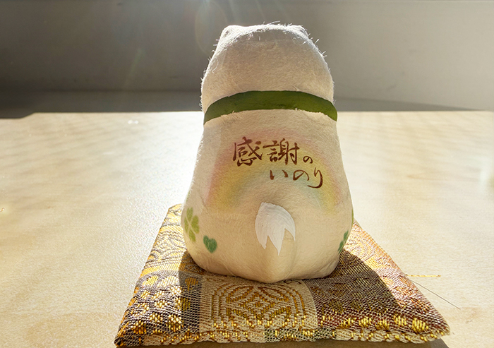 背中側の写真。虹のイラストと感謝の祈りと習字で描かれている