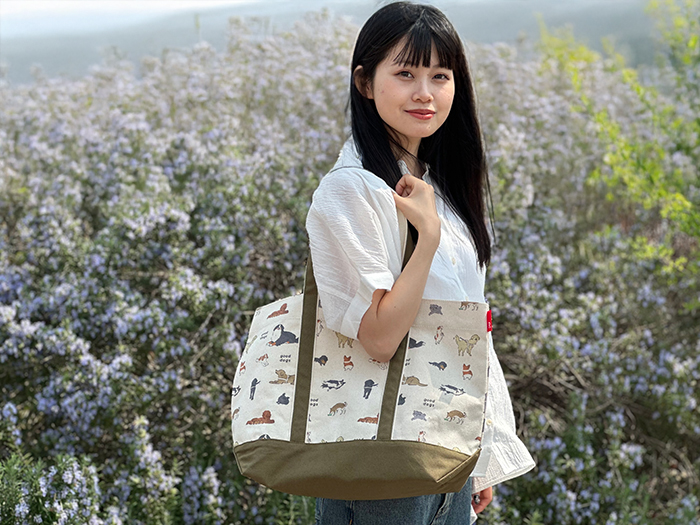 女性が肩からミディアムサイズのトートをかけている写真