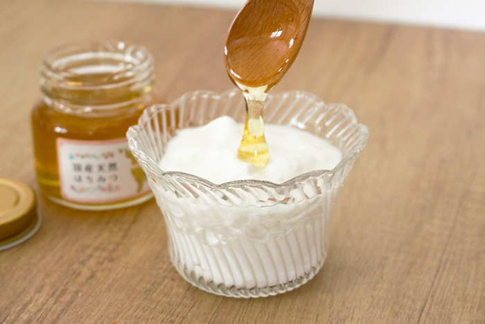 蜂蜜をヨーグルトにかけている。