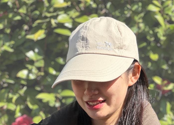 女性モデルがキャップをかぶっている写真。