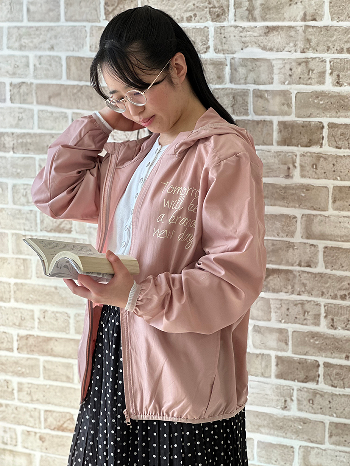 女性がスモーキーピンクのパーカーを着て女性らしい服装に羽織っている写真