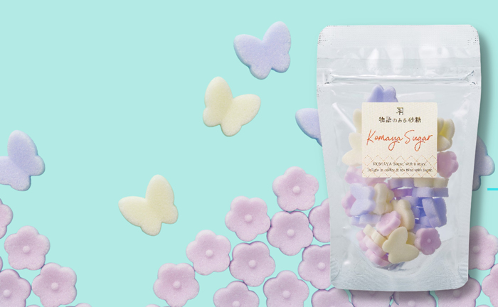 パステル調のピンクの小花とラベンダーカラー、黄色の蝶々型の砂糖の写真