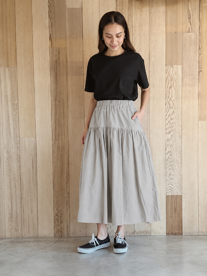女性がスカートを着用して正面を向いている写真