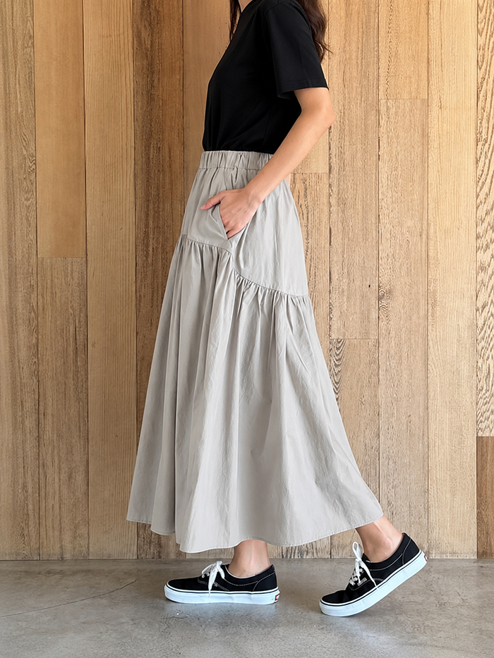女性がスカートを着用して横を向いている写真
