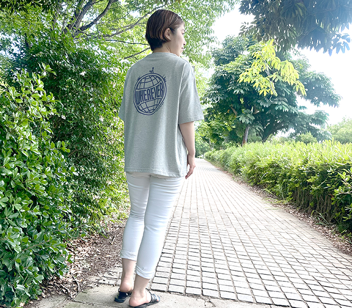 女性がグレーのTシャツの下にホワイトデニムを着用している写真。