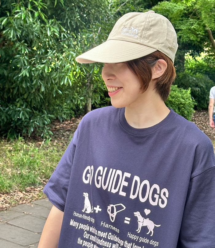 女性がネイビーのTシャツを着用し、ベージュのキャップを被っている写真